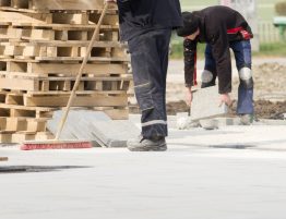 Image showing construction site workers sweeping and tidying up materials