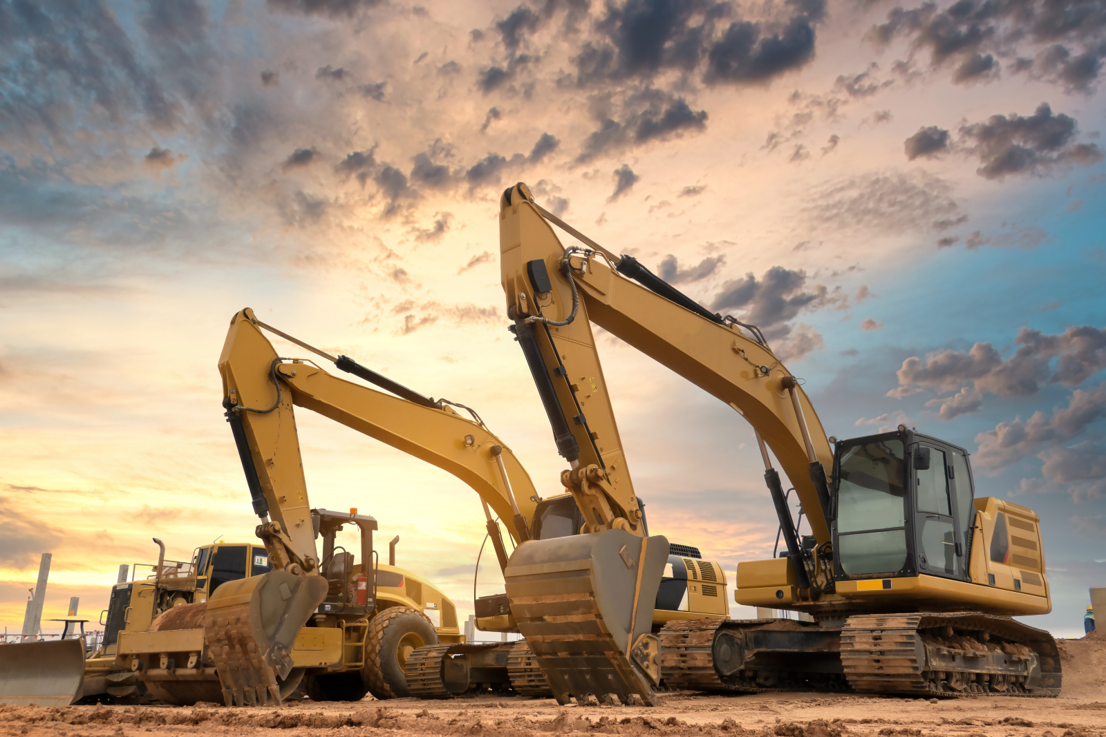 Image of two excavators on a construction site with a dramatic sky in the background