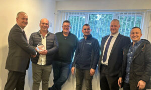 Image of team members from Sheriff Construction (office and site staff) receiving an award from IKO’s Group Managing Director and Area Business Manager