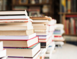 Image showing piles of books set out on a table with a blurred book store background.