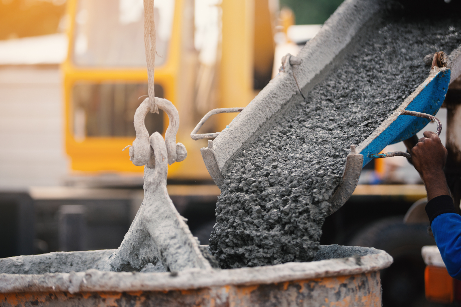 Images showing concrete being poured into a crane bucket