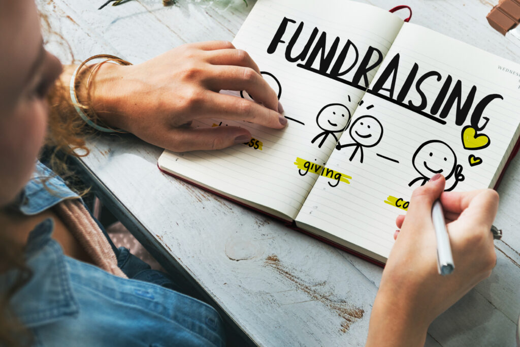 Close up of a woman working on a fundraising plan in a notebook
