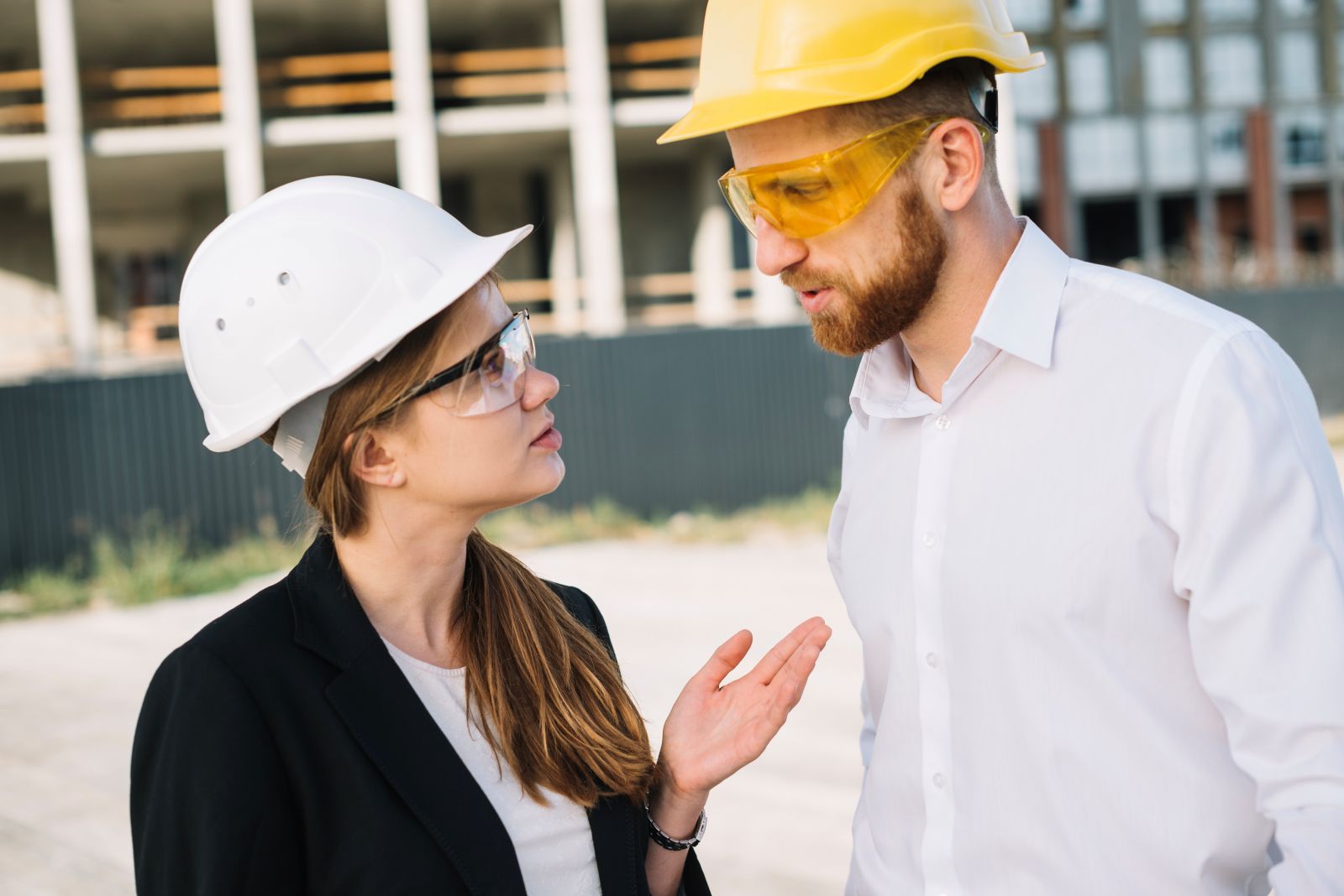 A man and a woman on a construction site talking face-to-face