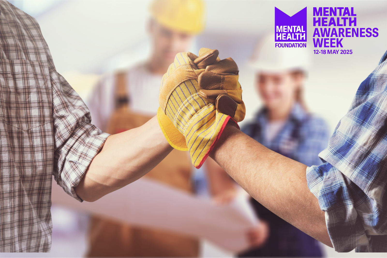 Close up of two construction workers arms (with hands shaking) with other workers standing behind them. Also featuring the Mental Health Awareness Week logo.