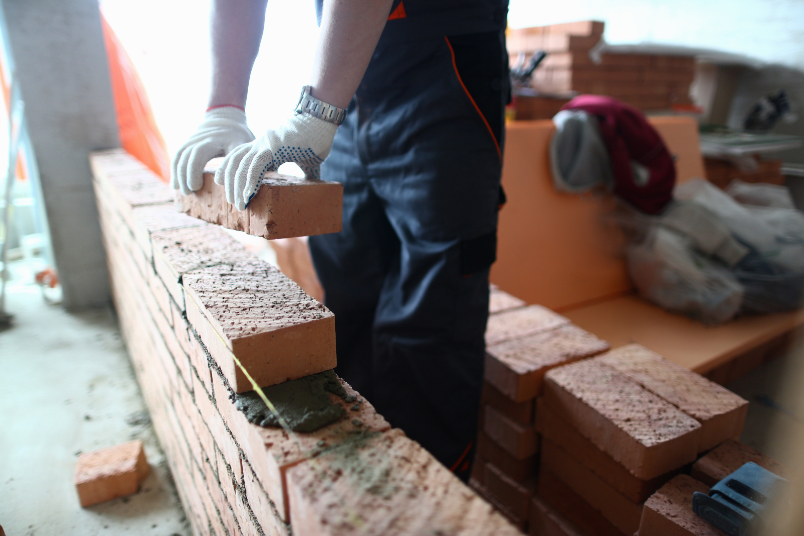 Close up of someone laying bricks in a straight line