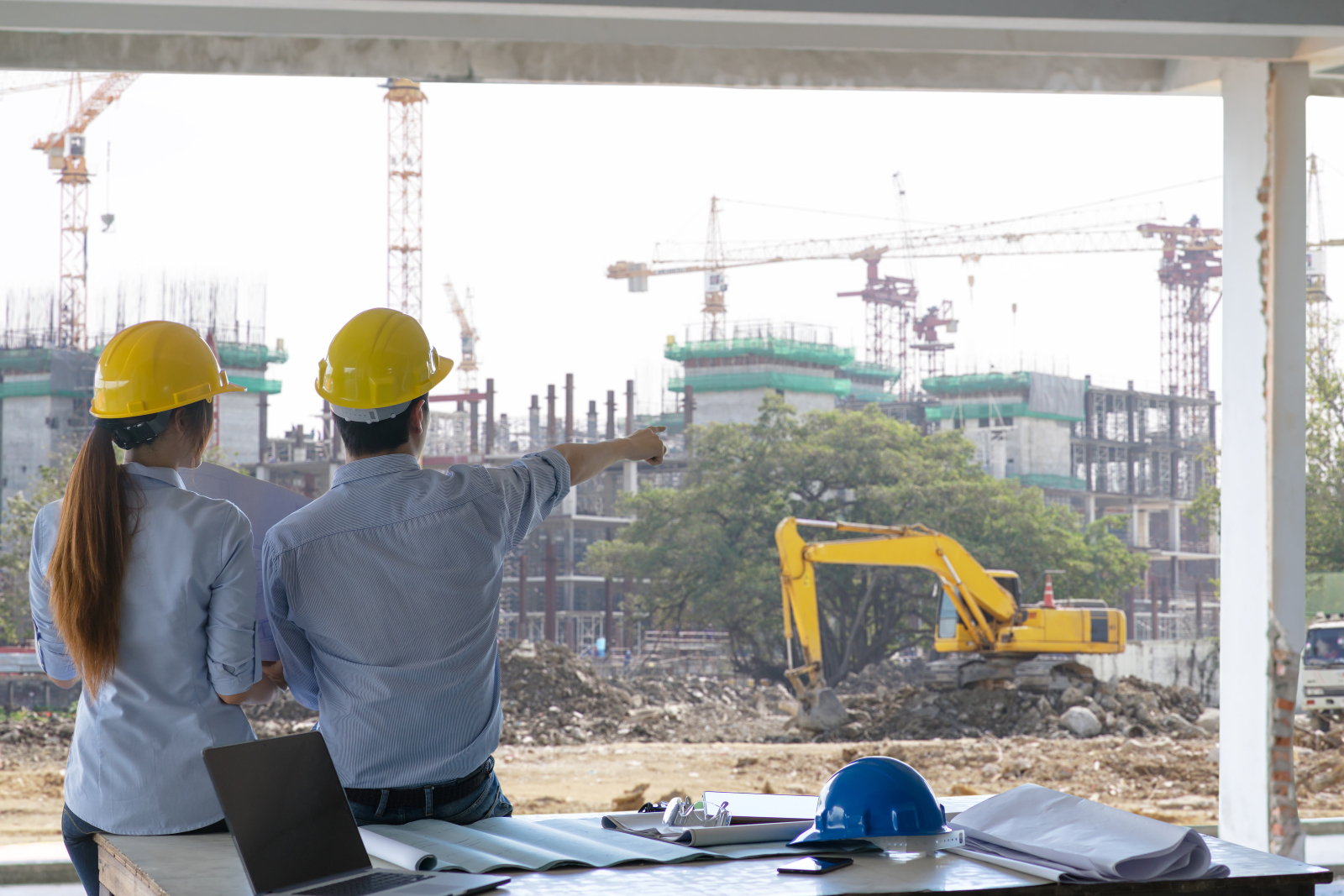 Two construction professionals looking over a busy construction site