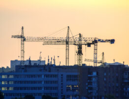 Construction site silhouetted against an early evening, darkening sky