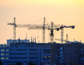 Construction site silhouetted against an early evening, darkening sky