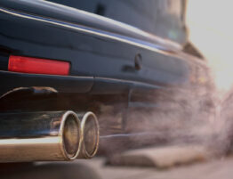 Close up of rear end of a car showing the exhaust emitting fumes