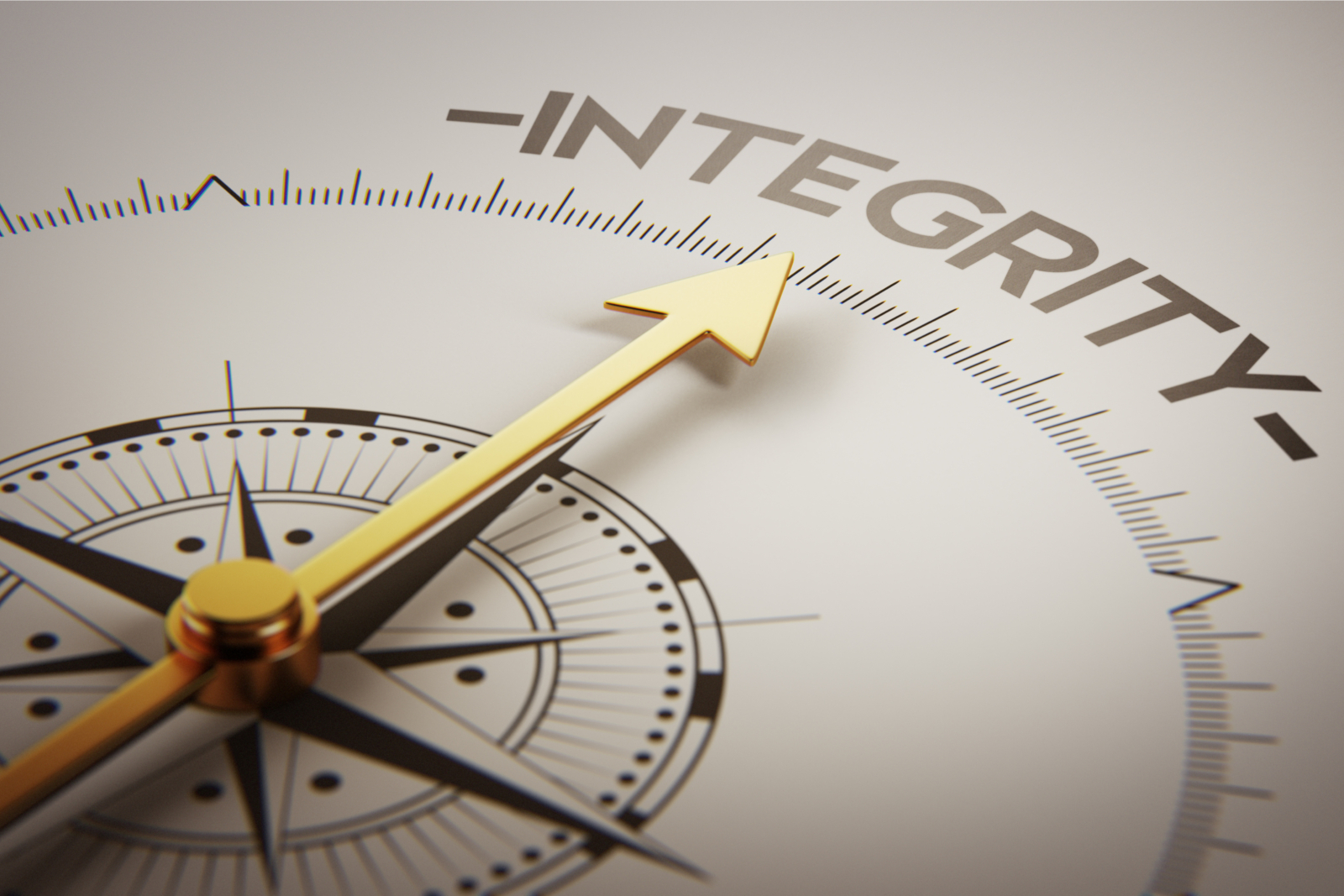 Close up of a compass with a gold arrow pointing towards the word 'integrity'.