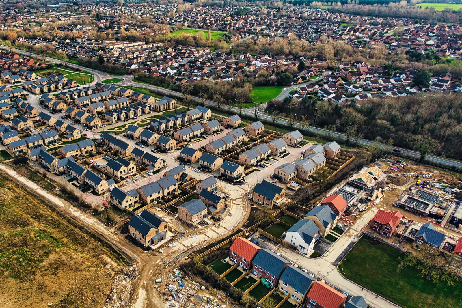 Aerial photo of a housing development, partially completed with views of the wider urban environment in the background.